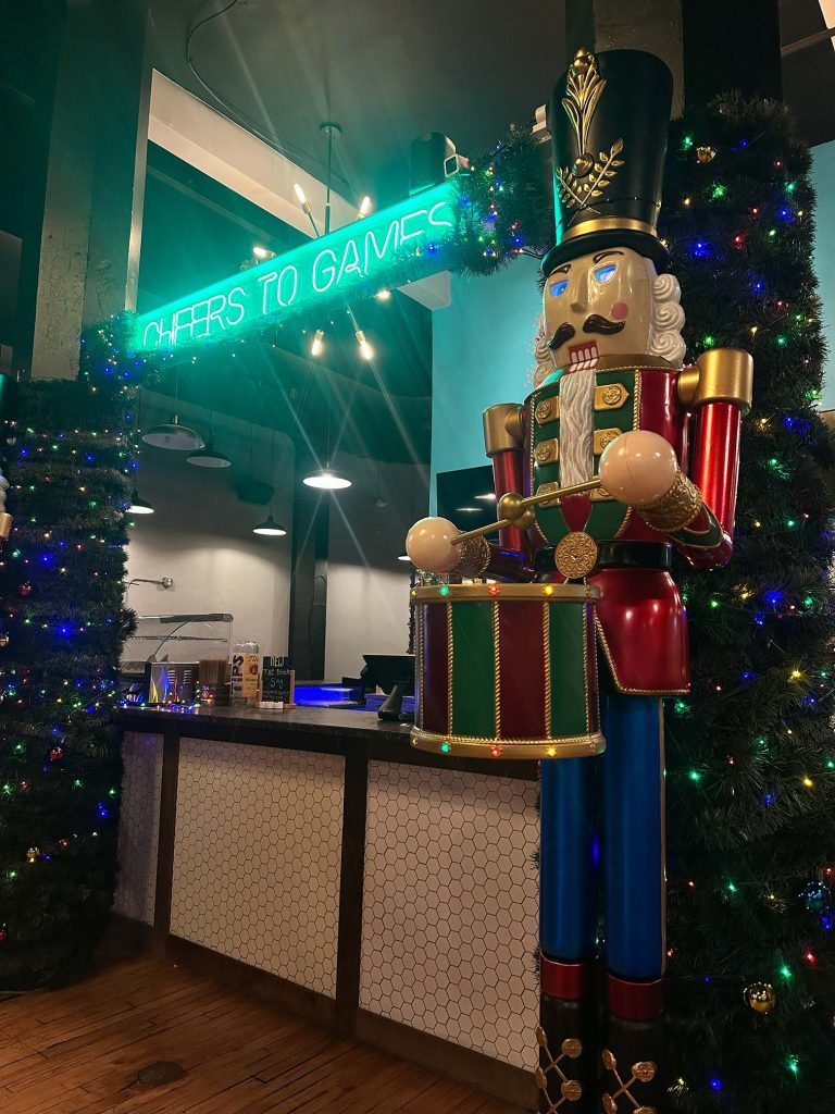 A life-sized Nutcracker statue and lighted Christmas trees welcome guests to Two Social bar, decorated for a Winter Wonderland holiday party in Dayton.